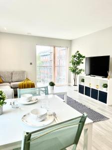 a living room with a white table and a tv at Deluxe 2 Bed 2 Bath Flat - Windsor, Heathrow Airport, Slough Station in Slough