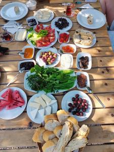 a wooden table with plates of food on it at Litost Cafe Bungalow in Adrasan