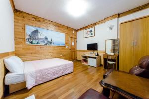 a bedroom with a bed and a desk and a tv at Donglifang B&B in Guanshan