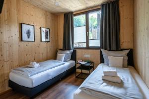 two beds in a room with two windows at Partnachlodge in Garmisch-Partenkirchen