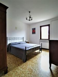 1 dormitorio con cama y ventana en La Casa di Raffaella - appartamento con giardino en Bracca