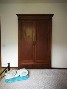 1 dormitorio con 1 cama y armario de madera en La Casa di Raffaella - appartamento con giardino en Bracca