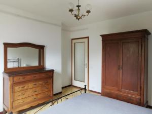 1 dormitorio con cama, tocador y espejo en La Casa di Raffaella - appartamento con giardino en Bracca