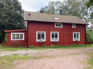 a red house with white windows in a yard at Forsnäsgården B&B in Stora Skedvi