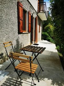 una mesa de picnic y un banco frente a un edificio en La Casa di Raffaella - appartamento con giardino en Bracca