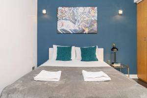 1 dormitorio con 1 cama grande y paredes azules en Stay Picadilly en Londres