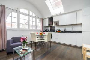 cocina y sala de estar con mesa y sillas en Stay Picadilly en Londres