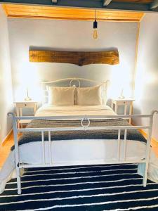 - une chambre avec un lit blanc et une tête de lit en bois dans l'établissement Casa da Venda Spa - Vista Gerês, à Montalegre