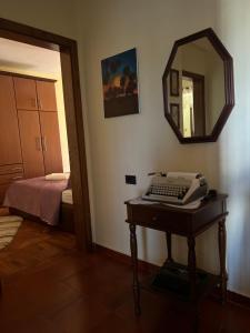 a room with a desk with a phone and a mirror at Apartament Qender in Elbasan