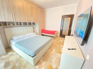 1 dormitorio con 1 cama y TV de pantalla plana en Milano relax family house, en Brugherio