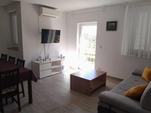 a living room with a couch and a table at Apartment Mikic in Čunski