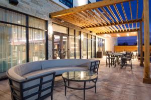 a patio with a couch and tables and chairs at Courtyard Kansas City Olathe in Olathe