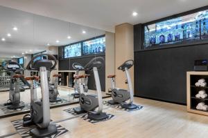 a gym with treadmills and a large screen at AC Hotel Brescia by Marriott in Brescia