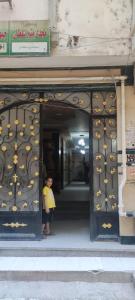 een vrouw die in de deuropening van een gebouw staat bij شقه فندقيه الترا لوكس in Asyut