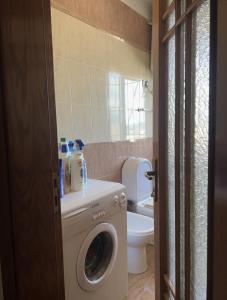 a bathroom with a washing machine and a toilet at Apartament Qender in Elbasan