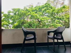 two chairs sitting on a balcony looking out a window at The Grand Hanthana in Kandy