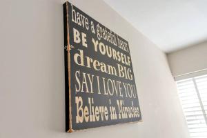 a sign hanging on a wall in a room at Coach House - Lovely 1 Bedroom Flat near Derby City Centre in Derby