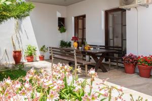 a patio with a wooden table and potted plants at The backyard- Κατοικία στην Αγριά, Βόλου in Agria