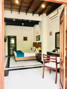 a bedroom with a bed and a desk and a chair at The Grand Hanthana in Kandy