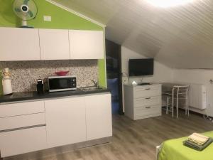 uma cozinha com armários brancos e um micro-ondas em Appartamento “Del TuF” in Sondrio Centro em Sondrio