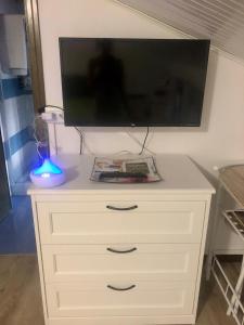 uma cómoda branca com uma televisão de ecrã plano por cima em Appartamento “Del TuF” in Sondrio Centro em Sondrio