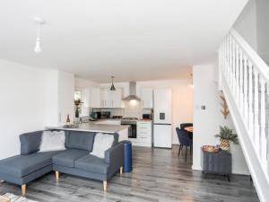 uma sala de estar com um sofá e uma cozinha em 39 Alwen Drive em Rhôs-on-Sea