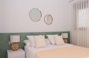een slaapkamer met een bed met twee spiegels aan de muur bij Apartamento con solarium en Jardines de Montesolana in Alicante