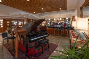a piano in a restaurant with a bar at Savoy Beach Hotel & Thermal Spa in Bibione