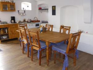 uma cozinha com uma mesa de madeira e cadeiras em Spreewaldpension Beesk em Raddusch