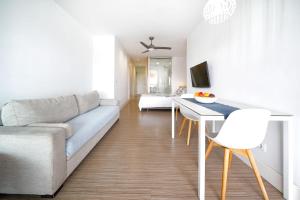 ein Wohnzimmer mit einem Sofa und einem Tisch in der Unterkunft Estudio con terraza vista mar in Las Palmas de Gran Canaria