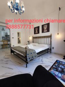 1 Schlafzimmer mit 2 Betten und einem Kronleuchter in der Unterkunft Casa Annita, casa vacanza in stile Sicilia, in pieno centro a Pachino in Pachino