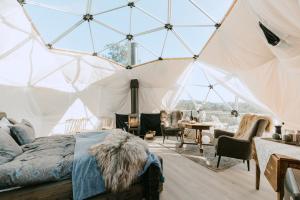 - une chambre dans une tente avec un lit et une table dans l'établissement Arctic Dome Namdalen, à Hoylandet