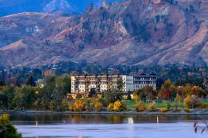 a hotel on the shore of a lake with mountains in the background at Residence Inn by Marriott Wenatchee in Wenatchee