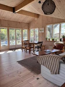 een woonkamer met een bank en een tafel met stoelen bij House with a lovely nature garden close to the sea 