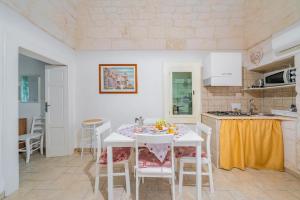 a kitchen with a white table and chairs in it at Salentina by Rentbeat in Ostuni
