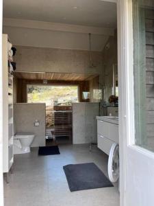 een badkamer met een toilet, een wastafel en een bad bij House with a lovely nature garden close to the sea 