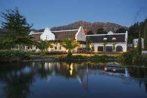a building with a lake in front of it at La Providence in Franschhoek