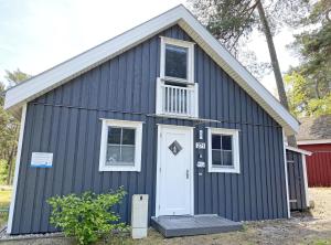 a black house with a white door and windows at Ferienhaus Sandkörnchen - Strandpark - ca. 80m Strand in Baabe