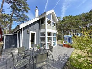 a tiny house with a table and chairs on a deck at Ferienhaus Sandkörnchen - Strandpark - ca. 80m Strand in Baabe