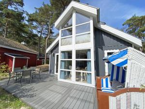 バーベにあるFerienhaus Sandkörnchen - Strandpark - ca. 80m Strandのデッキ(テーブル、椅子付)が備わる家