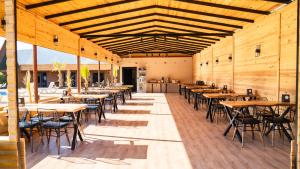 ein Esszimmer mit Tischen, Stühlen und Holzwänden in der Unterkunft Araz Wooden Concept in Kumluca