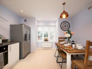 a kitchen and dining room with a table and a refrigerator at Pass the Keys Central Marlow townhouse with private parking in Marlow