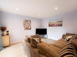 a living room with a couch and a television at Pass the Keys Central Marlow townhouse with private parking in Marlow