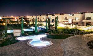 een zwembad voor een gebouw 's nachts bij Apartamento con solarium en Jardines de Montesolana in Alicante