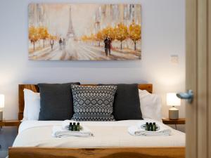 a bedroom with a bed with a painting on the wall at Pass the Keys Central Marlow townhouse with private parking in Marlow