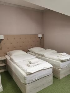 two beds in a room with white sheets at Rezydencja Pod Pieprzówkami in Zalesie Gorzyckie