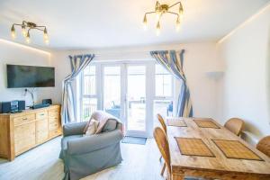 a living room with a wooden table and a dining room at Beachside Cottage - Camber Sands - Close to beach in Camber