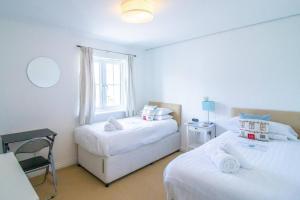 a bedroom with two beds and a window at Beachside Cottage - Camber Sands - Close to beach in Camber