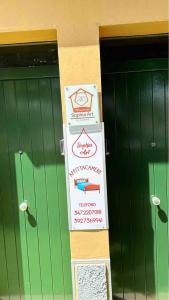 a stack of signs in front of two green doors at CORTICELLA 1 in Bologna