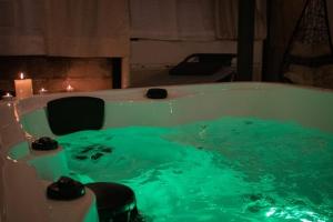 una vasca da bagno riempita di acqua verde con candele di Hotel San Giuseppe a Gerace